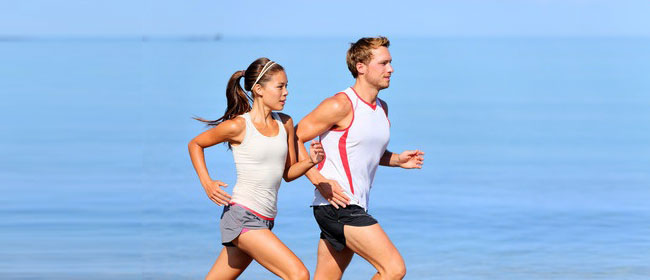 couple doing cardio training jogging on beach