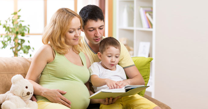 a pregnant mother with her husband and child