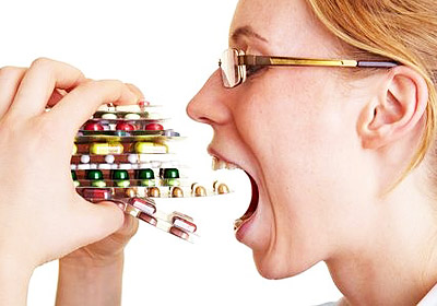 woman taking a bunch of pills
