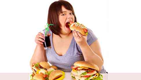 an obese woman eating junk food