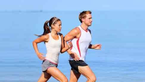 couple doing cardio training jogging on beach
