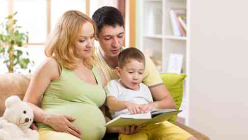 a pregnant mother with her husband and child