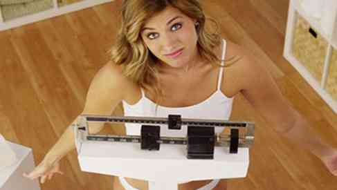woman measuring weight and calorie